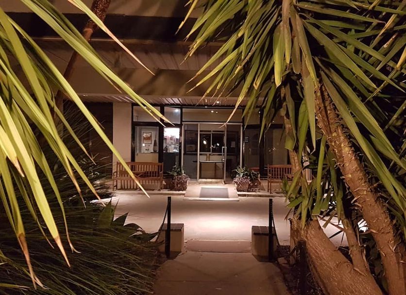 Night entrance to Kerang Valley Resort in Kerang, framed by palm trees and lit walkway