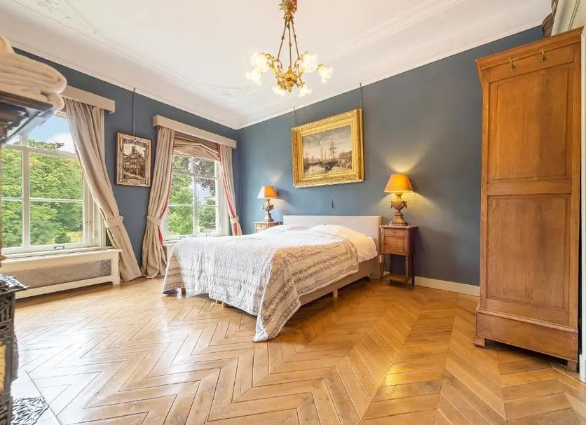 Logement Swaenenvecht in Oud-Zuilen: bright guest room with bed, blue walls, large windows and chandelier