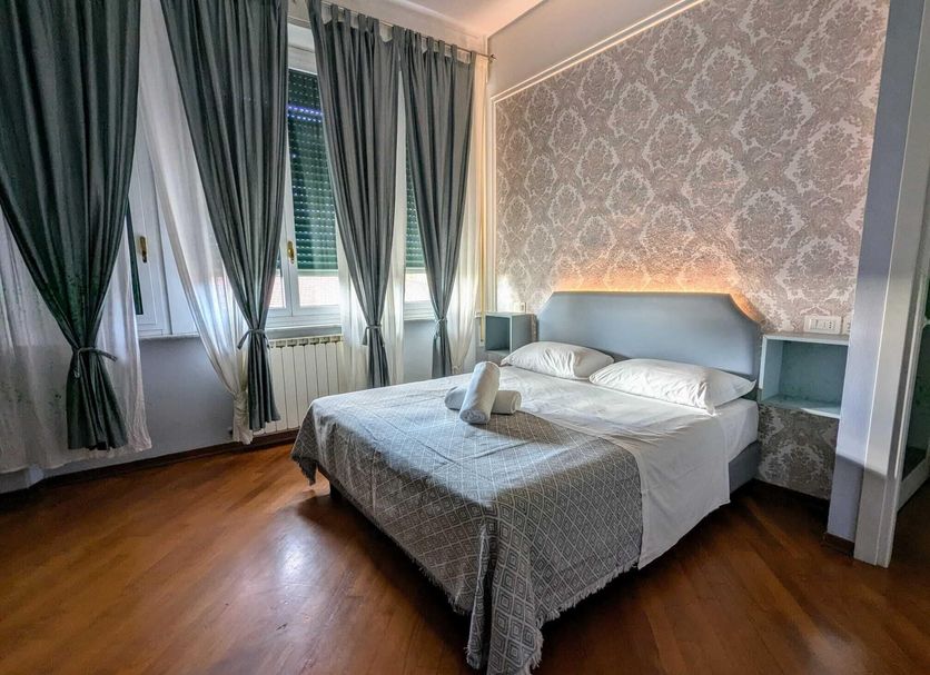 Hotel Soggiorno Athena, Pisa: double bed bedroom with patterned headboard, curtains and wood floor