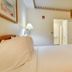 Vagabond Inn Hacienda Heights guest room with a king bed, lamp, mini fridge and open bathroom door