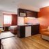 Motel 6 El Paso - Southeast room with sofa, kitchenette, bed and orange accent wall