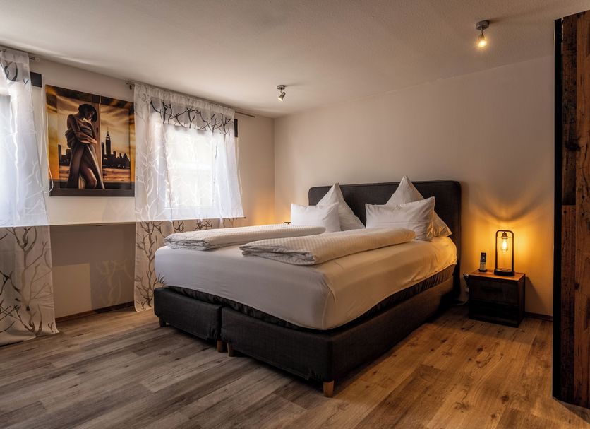 Ochsen in Bad Saulgau guest room with double bed, bedside lamp, and warm wood flooring
