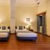 Umed Bhawan Palace in Kota guest room with two twin beds, wooden floor, desk, and curtains
