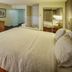Hampton Inn South Haven guest room with king bed, desk, TV, and visible bathroom vanity