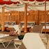Royal Sun Palm Springs lounge chairs under a red canopy beside a shaded cabana in Palm Springs