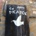 Albergue Rural Cal Picarol sign painted on a rustic wooden board against a stone wall in Àger.