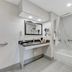 Quality Inn Laurinburg bathroom with vanity, lit mirror, and tub-shower combo