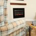 Broom Hall Inn in Alcester lounge with plaid sofa, leather chair, and electric fireplace