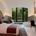 The Roseate New Delhi guest room with king bed, soaking tub, desk, and forest view through large windows