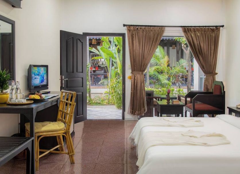 The Oasis Harbor in Siem Reap guest room with twin beds, desk, open door to garden, and terrace view