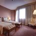 Borgo Palace Hotel in Sansepolcro guest room with two twin beds, lamps, chair and large window