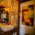 Tiradentes Village bathroom vanity with patterned tile wall, lanterns, and red flowers in Tiradentes