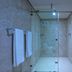 Econo Express Hotel Mexico City bathroom with glass-enclosed shower and marble-look tile walls