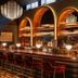 The Flat Iron Hotel in Asheville bar with arched backlit shelves, stools, and warm ambient lighting