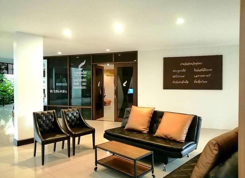 Nana Buri Hotel in Chumphon lobby with black chairs, sofa, coffee table, and glass doors