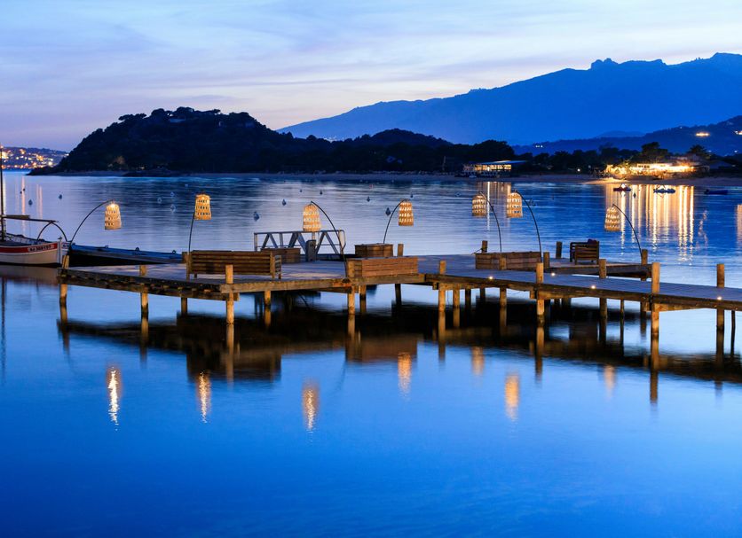 Grand Hôtel De Cala Rossa, Porto-Vecchio: tranquil waterfront pier with boats and mountain views at dusk