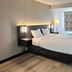 Studio 6 Suites Elkhart, IN guest room with king bed, bedside lamps and window with patterned shade