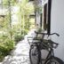 Ristolocanda Grani di Pepe in Flaibano, garden walkway beside a hotel building with chairs and bicycles