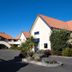 Bella Vista Motel Kaikoura in Kaikoura with white motel buildings, red roofs and landscaped entrance