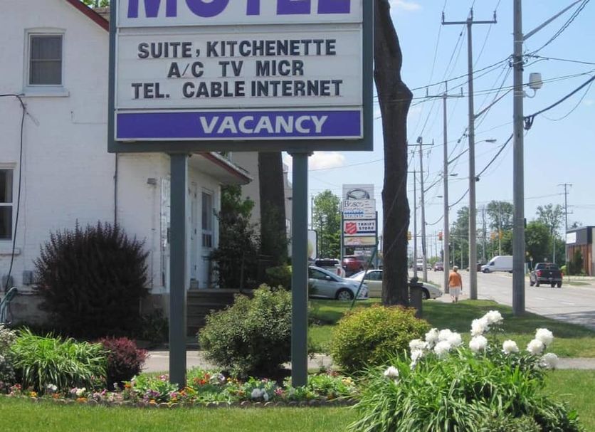 Rosecourt Motel in Stratford exterior with roadside sign, flower bed, and street view