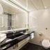 Maritim Hotel Bremen bathroom with black vanity, wall-mounted toilet and glass shower in Bremen