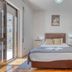 Hotel Borsalino Porto guest room with bed, bedside lamps, balcony door and wooden floor