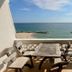 Banchaitalay Room in Rayong balcony with table and chairs overlooking a calm sea and beach