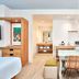 Universal Endless Summer Resort Dockside Orlando guest room with kitchenette, dining table, and two wicker chairs