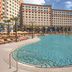 Universal Endless Summer Resort Dockside in Orlando with a large outdoor pool, palm trees, and hotel towers