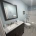 Coastal Inn and Suites Long Beach bathroom with vanity, mirror, toilet, and shower-tub combo