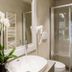 Relais Tosinghi Florence bathroom with orchid, white sink, towel warmer and glass shower
