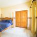 Tanjung Alam Hotel in Buleleng room with a wooden four-poster bed and wardrobe