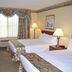 Baymont by Wyndham Waterford/Burlington WI room with two beds, desk, lamps and window drapes