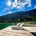 Hotel Pinzolo-Dolomiti in Pinzolo with loungers on a wooden dock beside a mountain lake