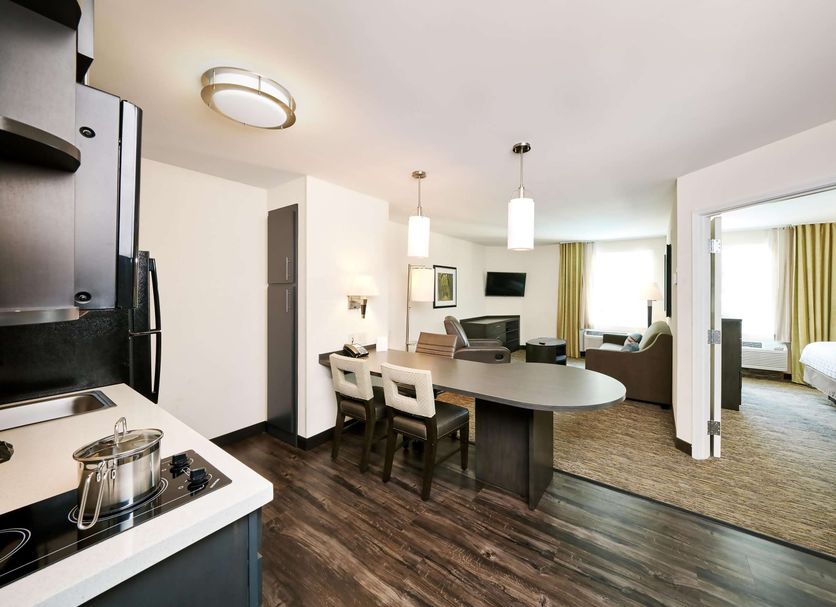 Sonesta Simply Suites Chicago O'Hare Airport suite with kitchen, dining table, and living area in Schiller Park