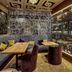 Cascada Boutique Hotel Lucerne lounge with plush seating, wood tables and illuminated glass wine display