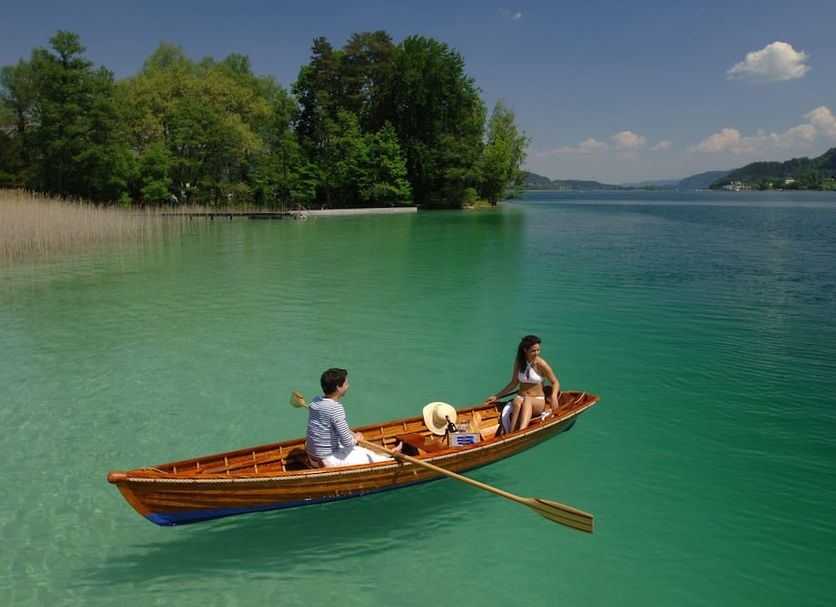 Barry Memle Directly at the Lake in Velden am Wörthersee: wooden boat on clear lake with two people