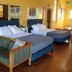 The Marquette Hotel in Madison guest room with two blue beds, sofa, and hardwood floor