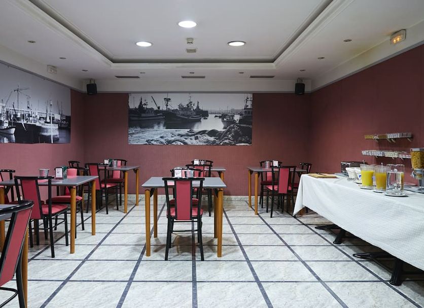 Hotel San Jorge in Santurtzi breakfast room with tables, red chairs, and a buffet table