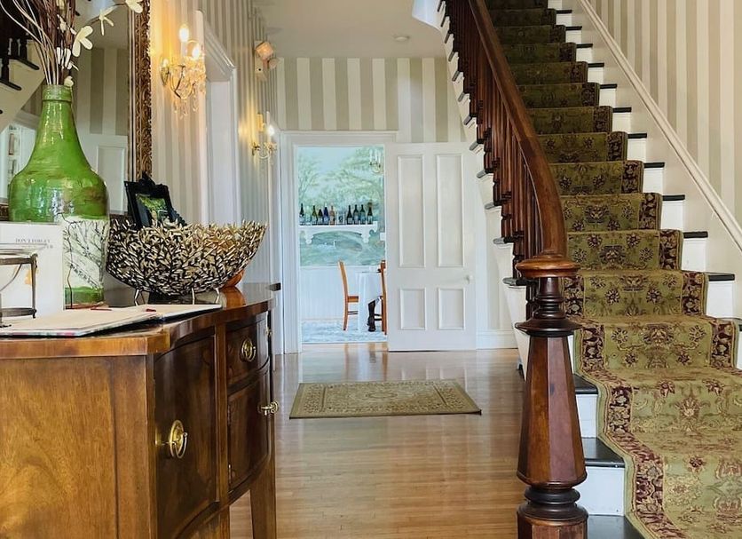 The Langworthy Inn & Winery lobby with staircase, wood furniture, and doorway to outdoor seating
