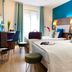 Hôtel Clairefontaine Paris twin guest room with teal accent wall, desk, and window seating