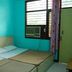 Hotel Viren Plaza in Agra guest room with two single beds, turquoise walls, and a window AC unit