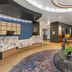 Cambria Hotel Spokane Airport lobby with curved orange seating and front desk in Spokane