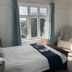Gwyndra House B&B in St. Austell bedroom with twin window, armchairs, and a neatly made bed