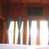 Wood House Pattaya room with wood ceiling, curtains and bright balcony doors in Pattaya
