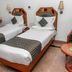 Hotel Maurya International in Chennai: twin beds, wall lamps, vanity mirror and side table in a guest room