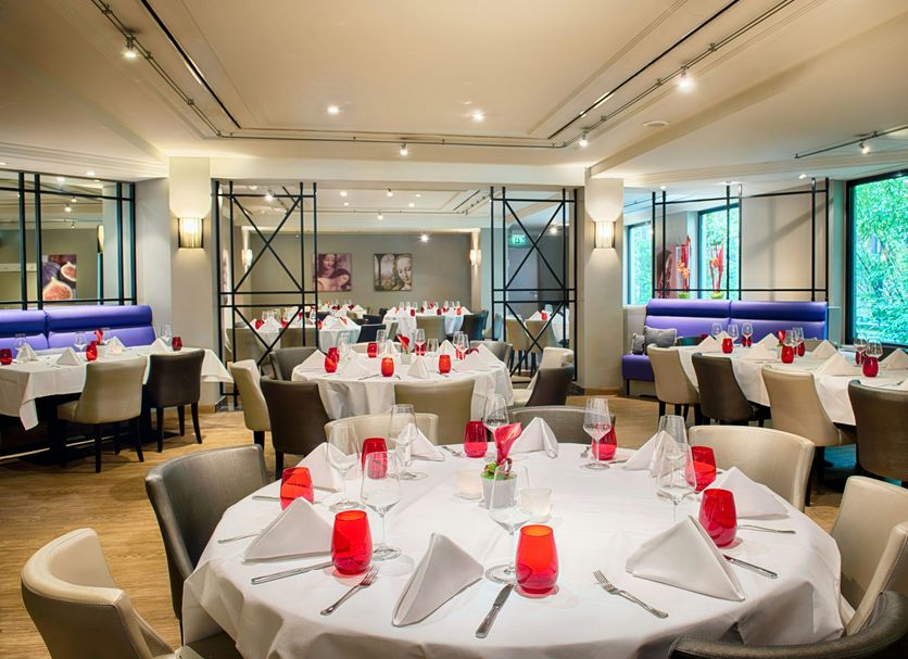 Leonardo Royal Hotel Düsseldorf Königsallee restaurant with round table settings and modern seating in Düsseldorf