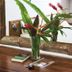 Otro Lado Lodge And Restaurant in Santa Teresa: tropical flower arrangement on a wooden table beside a mirror