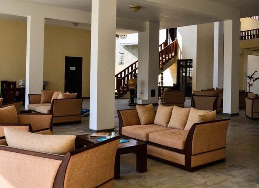 Marina Beach Passikudah lobby seating area with sofas, tables, and staircase in Kalkudah