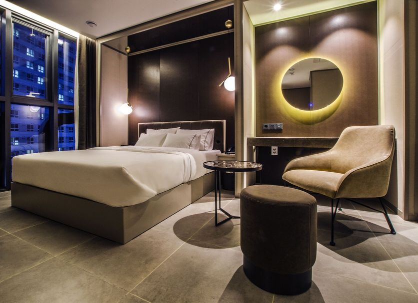 Hotel The Designers Premier Seongsu and Konkuk Univ room in Seoul with bed, chair, round mirror and city view